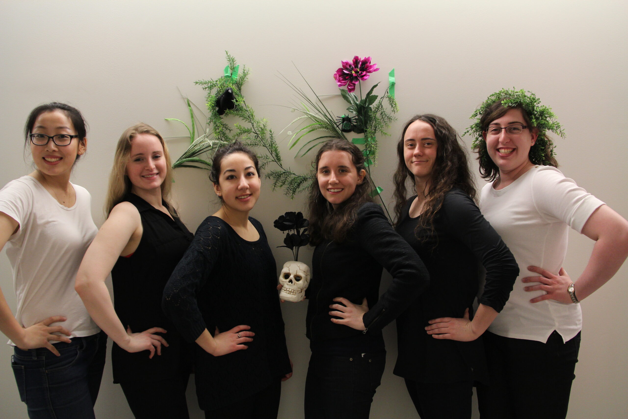 Other People team posing in front of wall with flowers