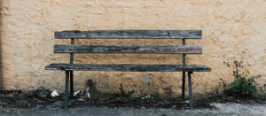 old bench against yellow wall