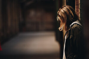 side profile of a girl in an alley looking down